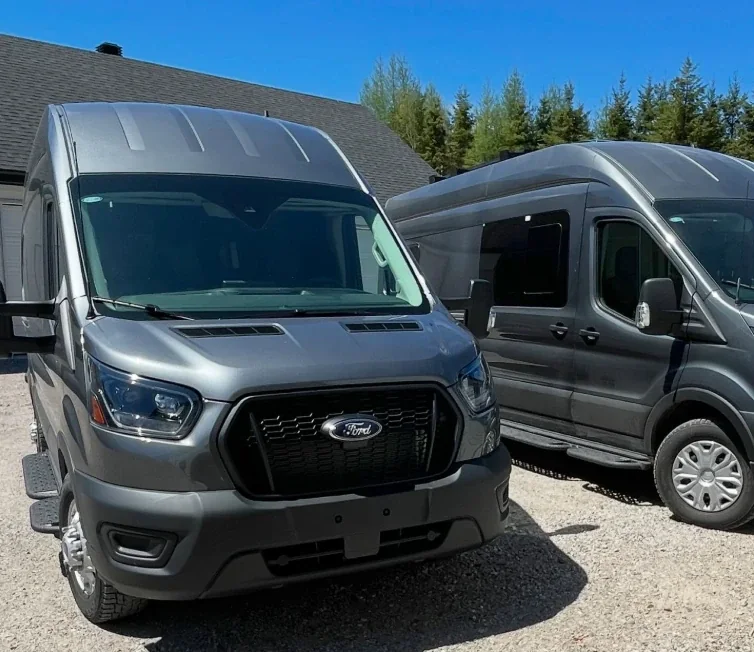 Les deux Ford Transit gris de Migration VR, vus de l’extérieur